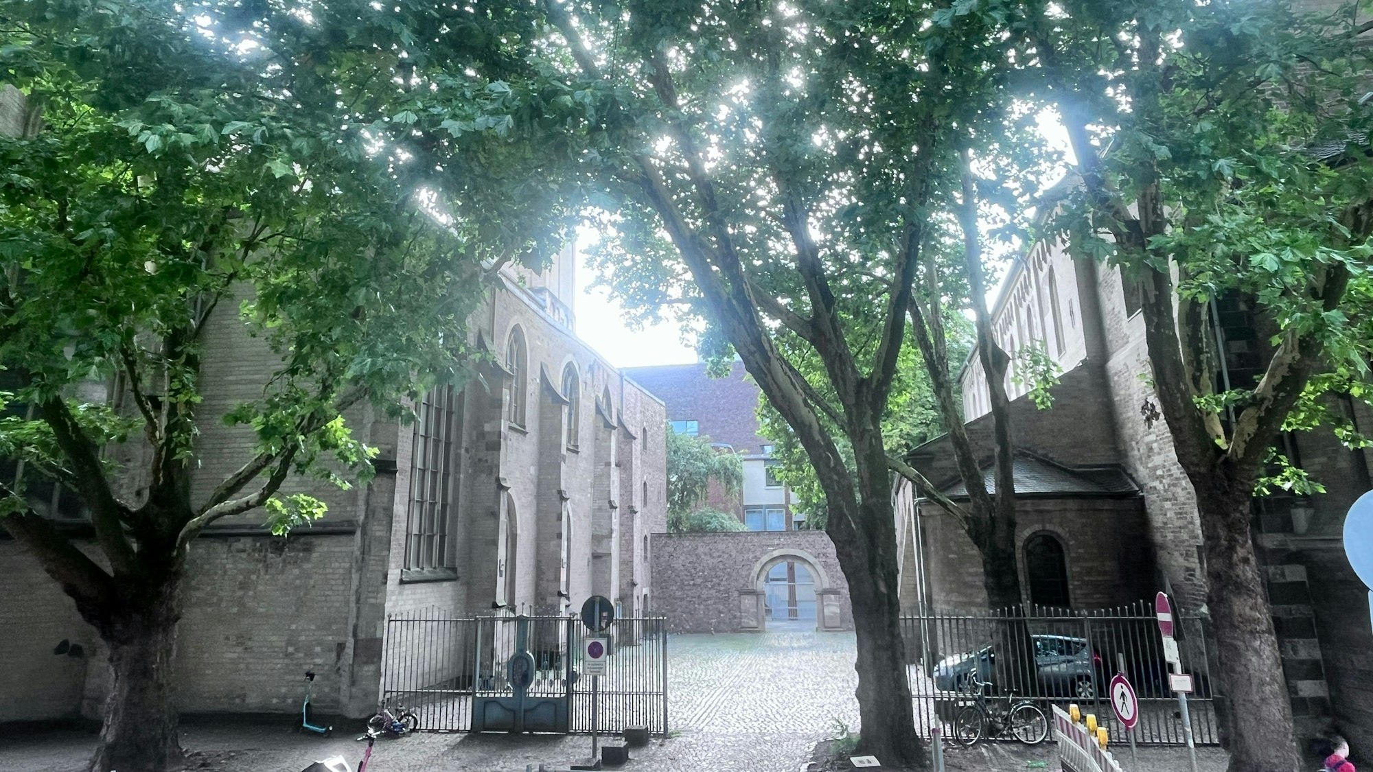 Blick auf eine Kirche mit einem geöffneten Gittertor, das den Eingangsbereich der Kirche absperrt.