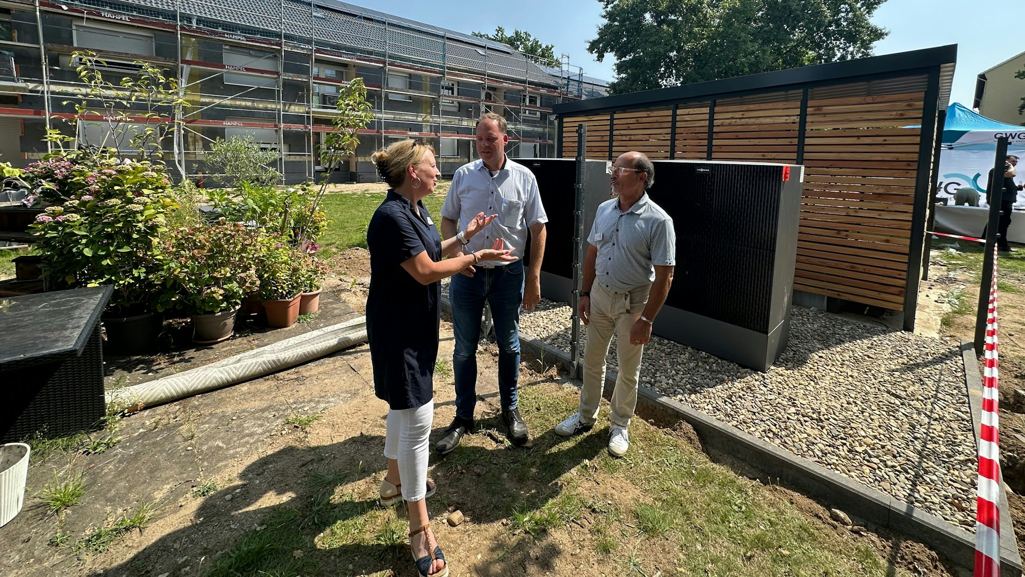 Mit einem Fest am 12. August 2025 wird der erste Bauabschnitt der Sanierung der Berliner Siedlung gefeiert. Regina Rostenstock, Thomas Kemmann als Geschäftsführer und Peter Krautkrämer als Projektleiter (v.l.). Im Hintergrund die neue Fahrradbox.