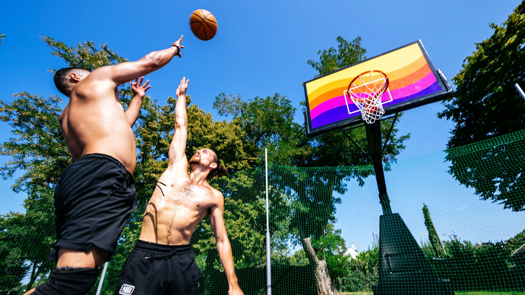Zwei Männer spielen Basketball.