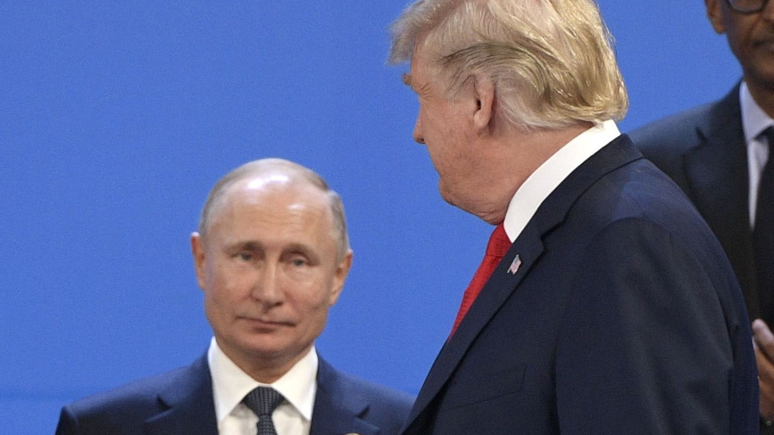 (FILES) US President Donald Trump (R) looks at Russia's President Vladimir Putin before posing for a family photo during the G20 Leaders' Summit in Buenos Aires, on November 30, 2018. US President Donald Trump said on August 8, 2025 he would meet with Russian counterpart Vladimir Putin on August 15 in Alaska, as the Republican billionaire hopes to help mediate an end to the war in Ukraine. (Photo by Juan Mabromata / AFP)