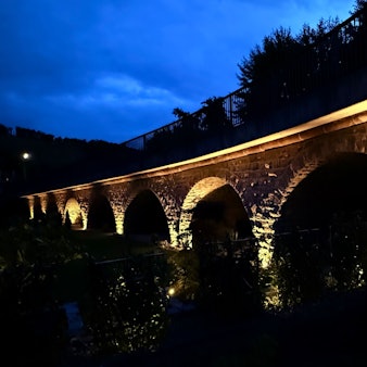 Eine angeleuchtete Bogenbrücke.