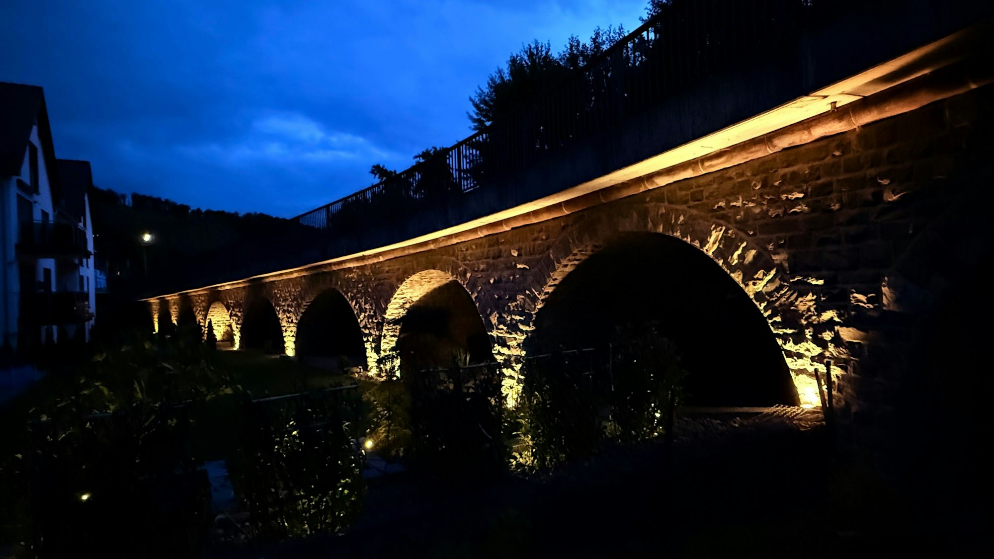 Eine angeleuchtete Bogenbrücke.