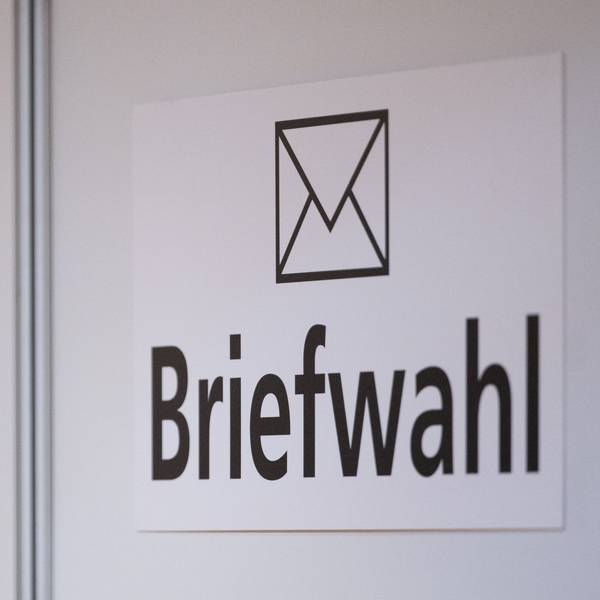 Das Wort Briefwahl ist im Foyer des Rathauses an einer Wand zu sehen.