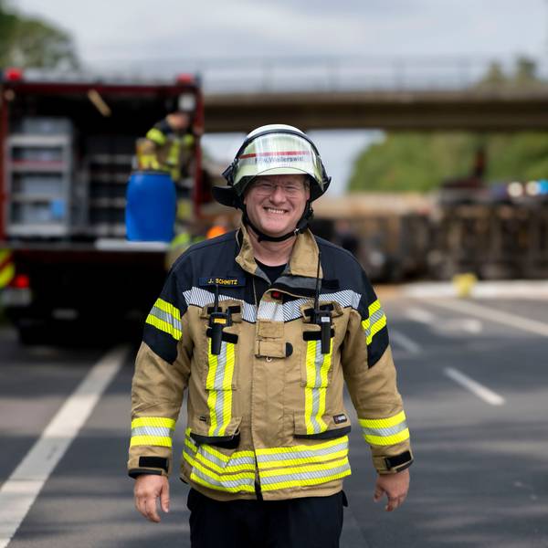 Das Bild zeigt Jürgen Schmitz in Feuerwehrmontur auf einer Straße.