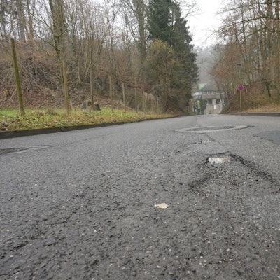 Die Dombach-Sander-Straße aus der Froschperspektive aufgenommen, zeigt die Schäden in der Fahrbahndecke.