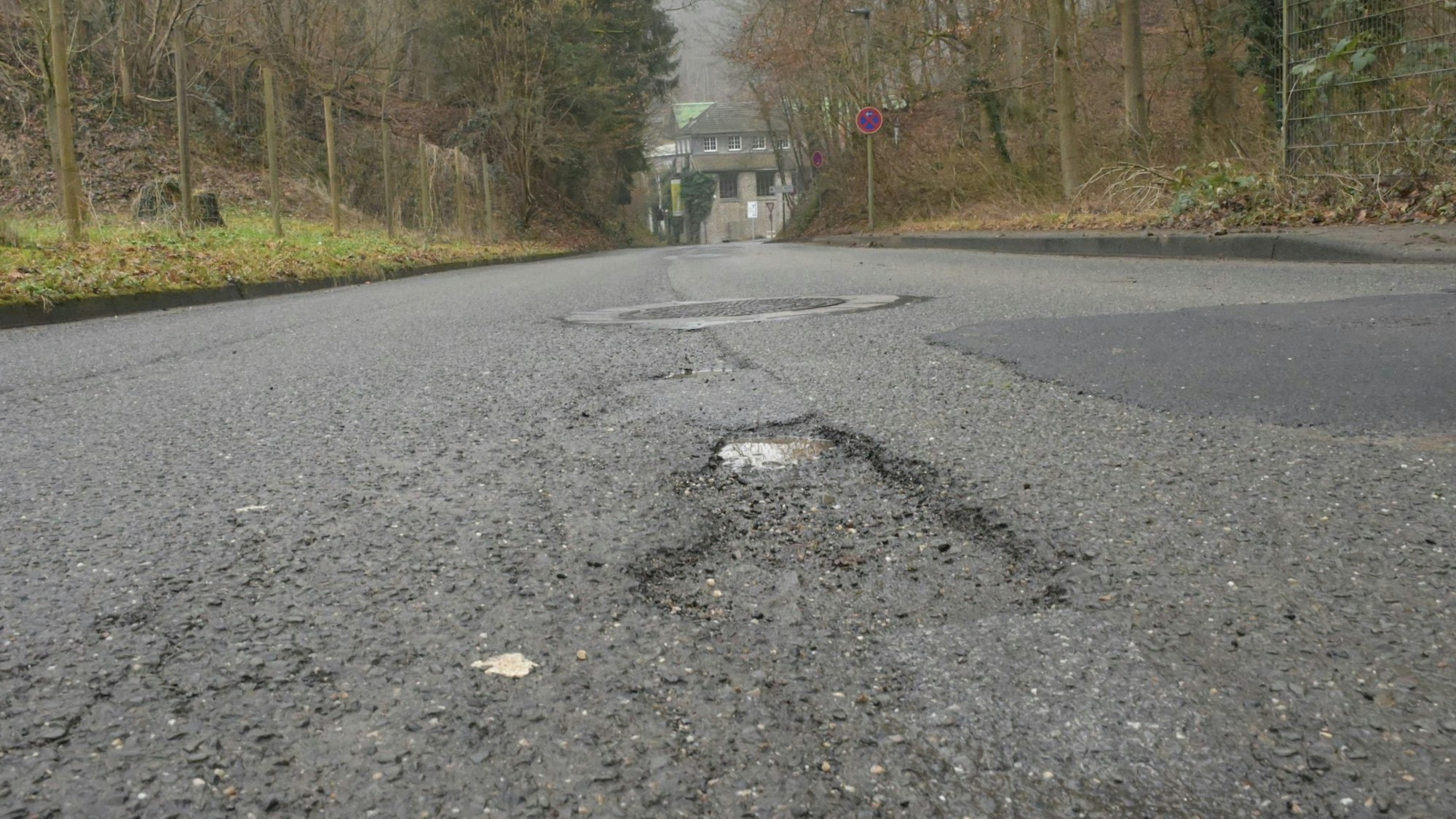 Die Dombach-Sander-Straße aus der Froschperspektive aufgenommen, zeigt die Schäden in der Fahrbahndecke.