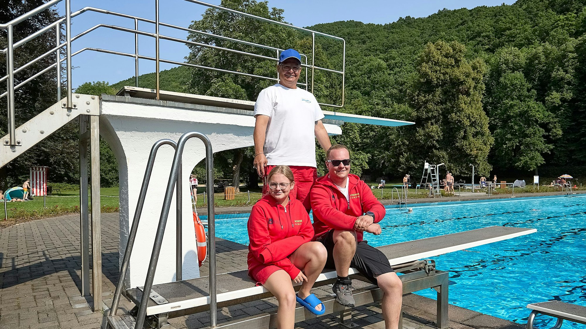 Die Gemünder Bademeister Thomas Engelmayer (hinten, Lena Engelmayer und Felix Mertens (vorne von links) posieren am Sprungbrett.
