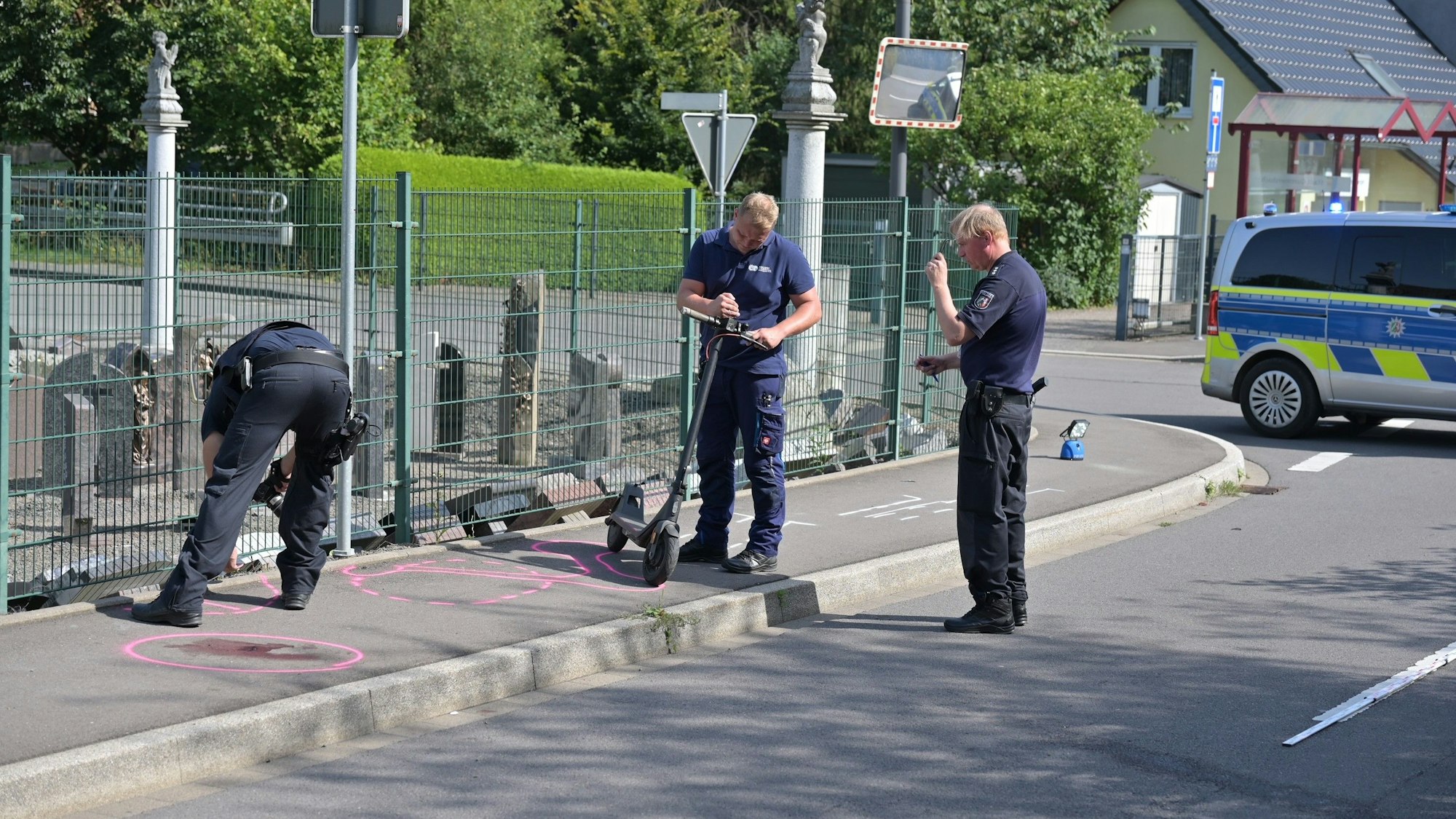 Drei Polizeibeamten arbeiten an der Unfallstelle.