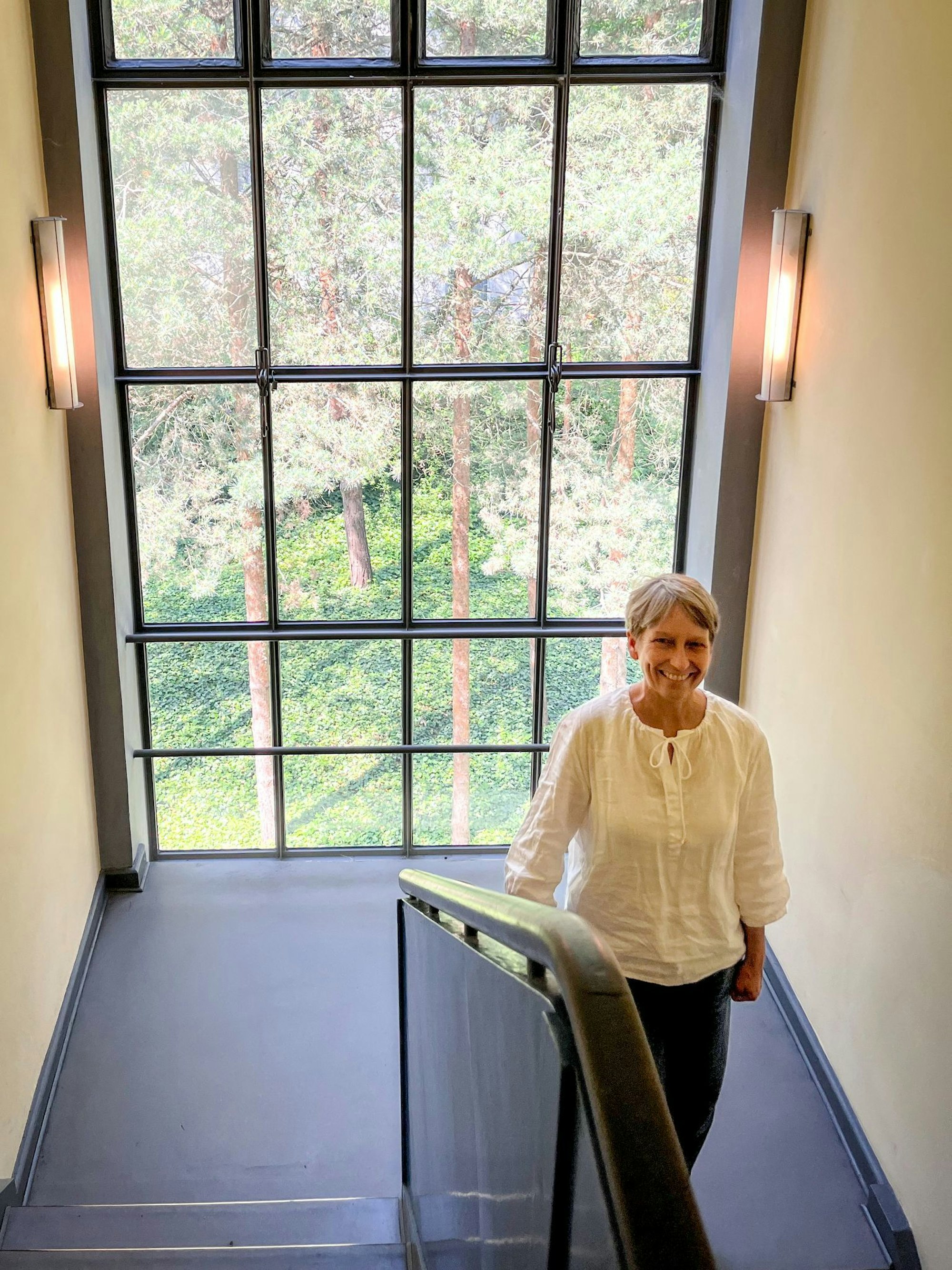 Dorothea Roos, Leiterin der Bauabteilung der Stiftung Bauhaus, steht vor der Glasfassade im Treppenhaus von Paul Klees Meisterhaus.