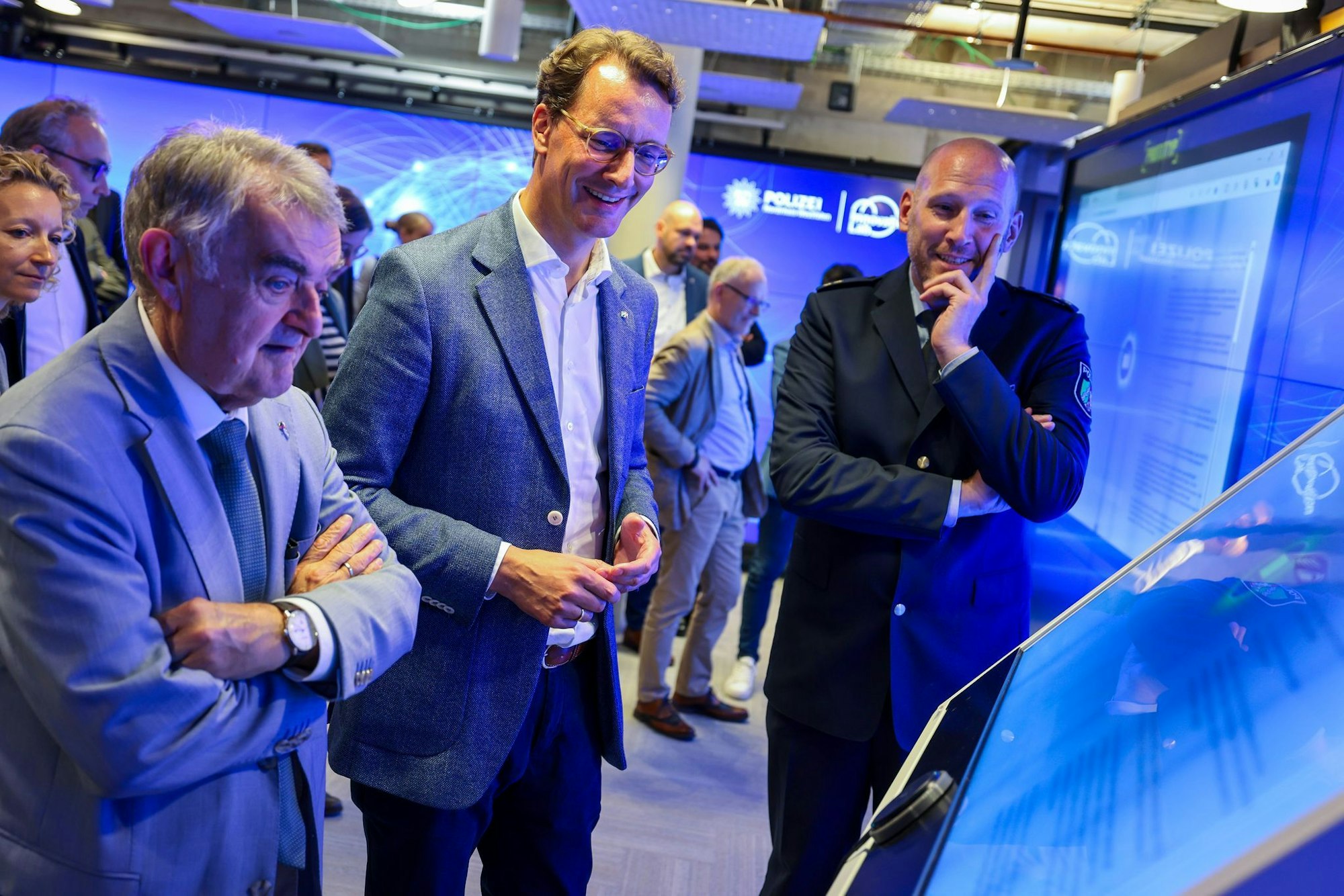 Innenminister Herbert Reul (CDU) und Ministerpräsident Hendrik Wüst (CDU) lassen sich von Leiter Dominic Reese (v. li.) das Innovation Lab vorführen (Archivfoto)