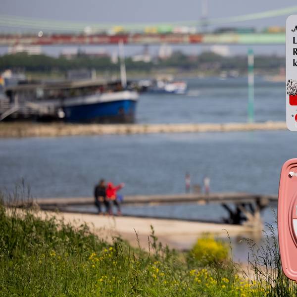 Ein Hinweisschild mit der Aufschrift „Achtung Lebensgefahr“ weist am Rhein in Köln-Rodenkirchen auf die Gefahren beim Schwimmen in dem Fluss hin.