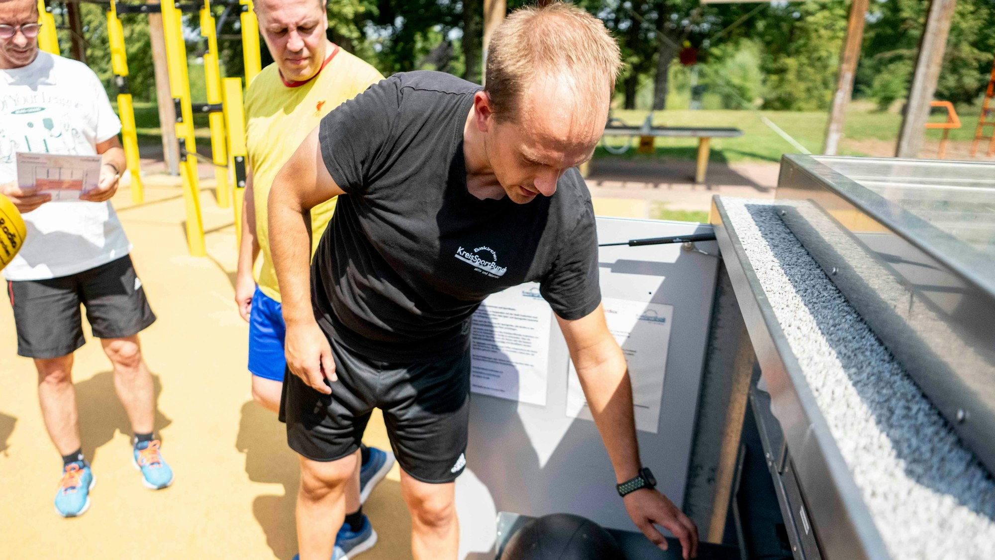 Das Bild zeigt einen Mitarbeiter des Kreissportbunds, der die Sportbox geöffnet hat.