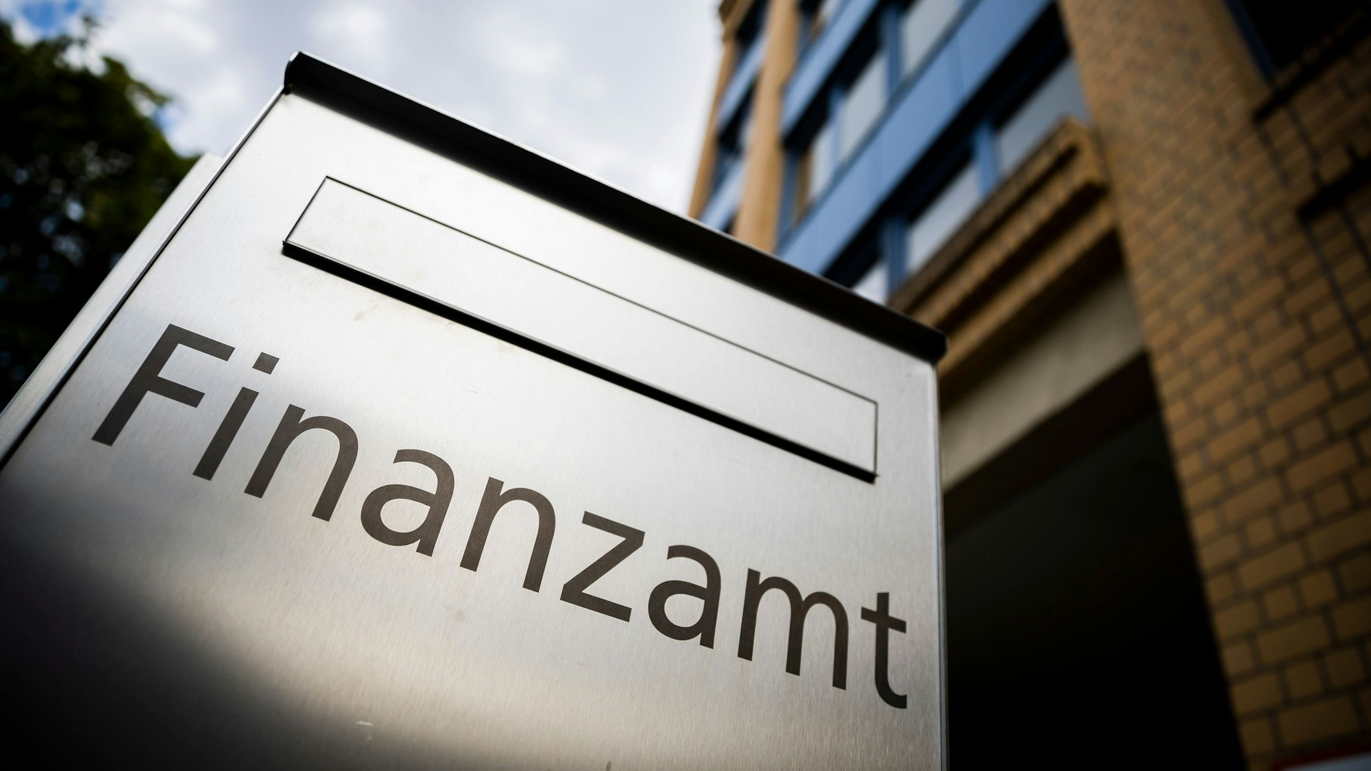 Ein Briefkasten des Finanzamtes steht vor einem Gebäude. (Archivbild)