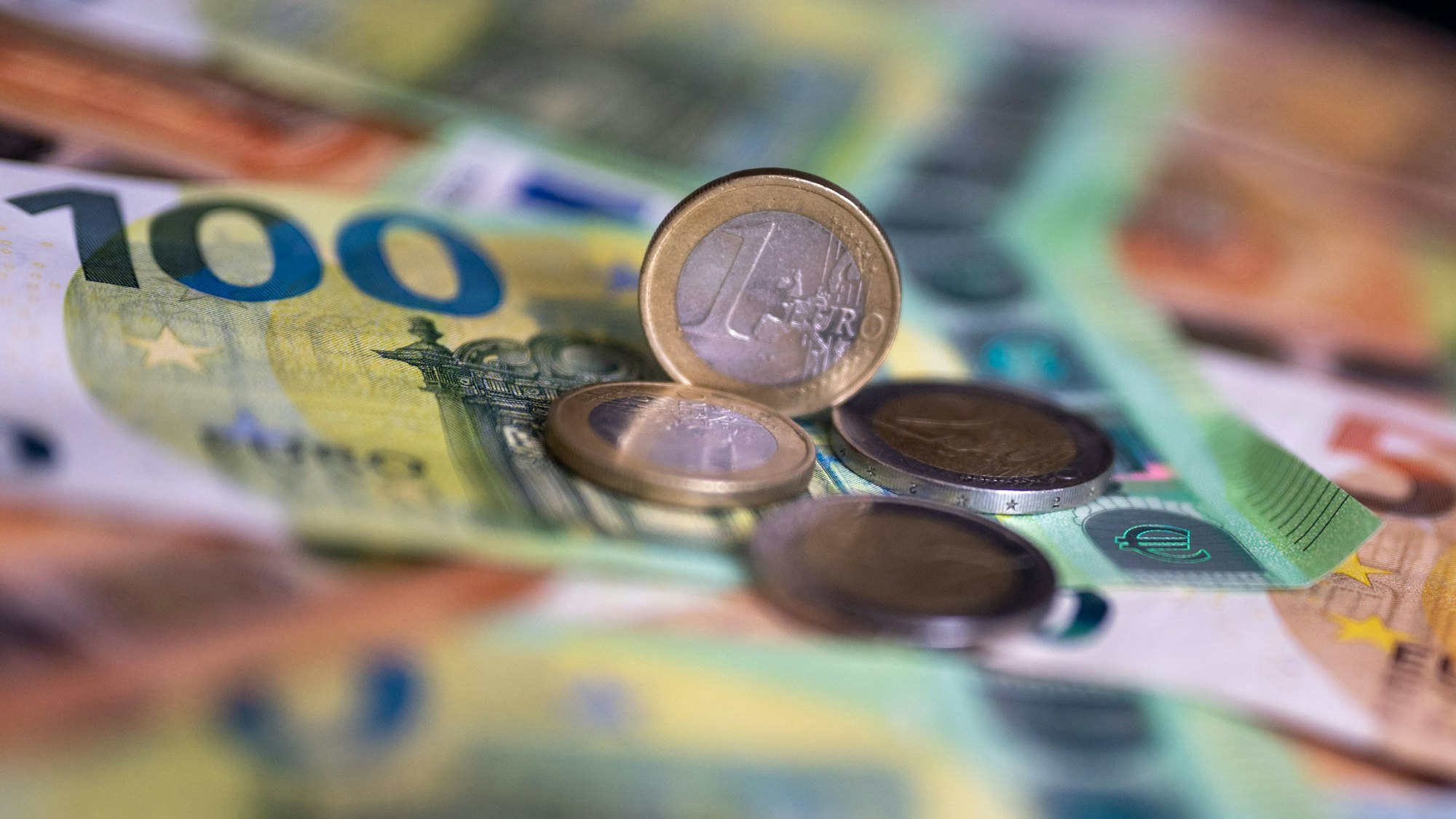 Geldscheine und Münzen liegen auf einem Tisch.