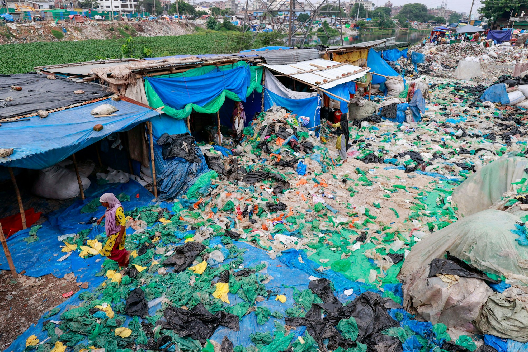 Bangladesch, Dhaka: Arbeiterinnen sortieren und trocknen gebrauchte Plastiktüten, nachdem sie sie in einer informellen Recyclinganlage in Dhaka, Bangladesch, gewaschen haben.