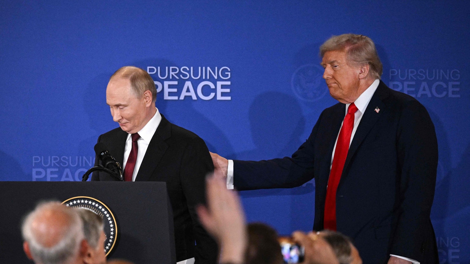 US President Donald Trump (R) and Russian President Vladimir Putin walk away after delivering a joint press conference after participating in a US-Russia summit on Ukraine at Joint Base Elmendorf-Richardson in Anchorage, Alaska, on August 15, 2025. (Photo by Drew ANGERER / AFP)