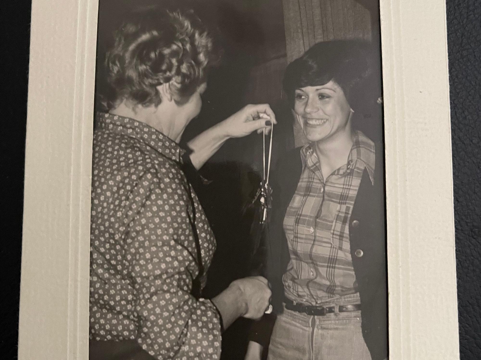Das Schwarz-Weiß-Bild zeigt Martha Bungart, der eine andere Frau einen Schlüssel übergibt.