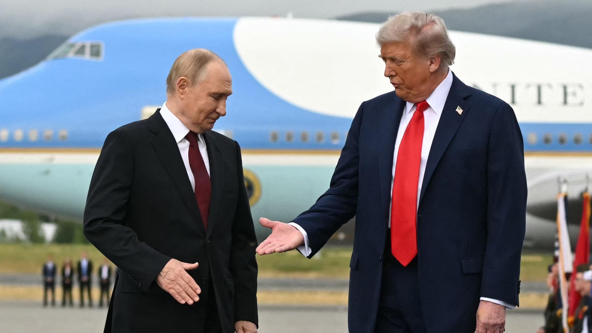 US Präsident Donald Trump (r) reicht Wladimir Putin die Hand.