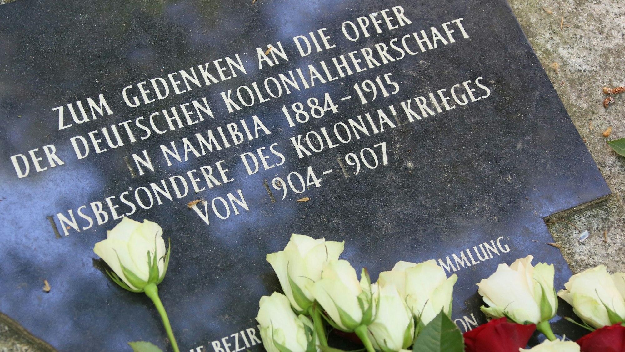 Blumen liegen auf dem Garnisonsfriedhof in Berlin am Gedenkstein für die Opfer der deutschen Kolonialherrschaft im heutigen Namibia. (Archivbild)