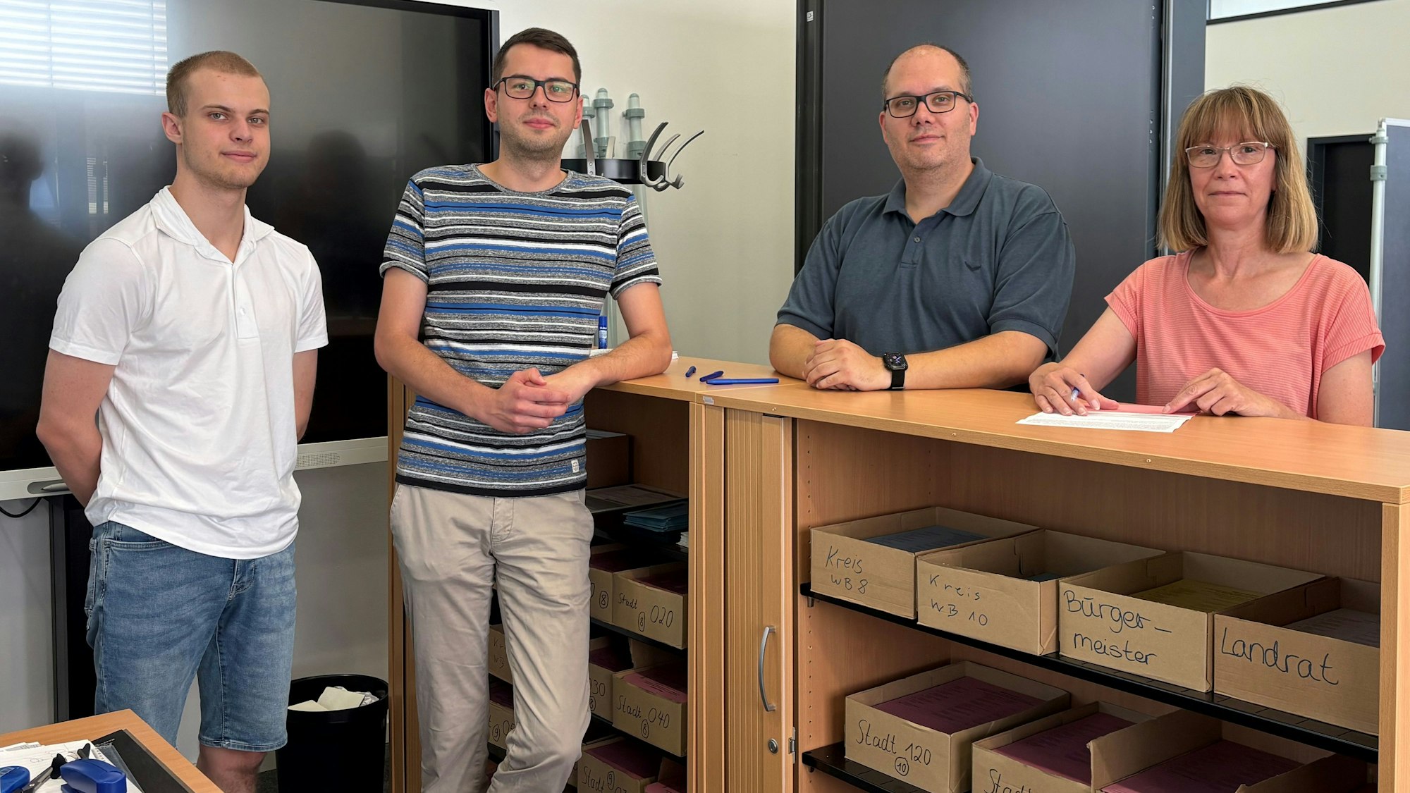 Vier Mitarbeiterinnen und Mitarbeiter des zehnköpfigen Teams. Felix Ratajszczak (Azubi zum Verwaltungsfachgestellten), Jens Holtkötter (Leiter Wahlamt), Andre Gensmann (Ordnungswesen) und Simone Zepp (Bürgerbüro Personenstandswesen). Mit der Betreuung der Direktwahl und dem Bearbeiten der Briefwahlanträge wechselt sich das Team ab.
