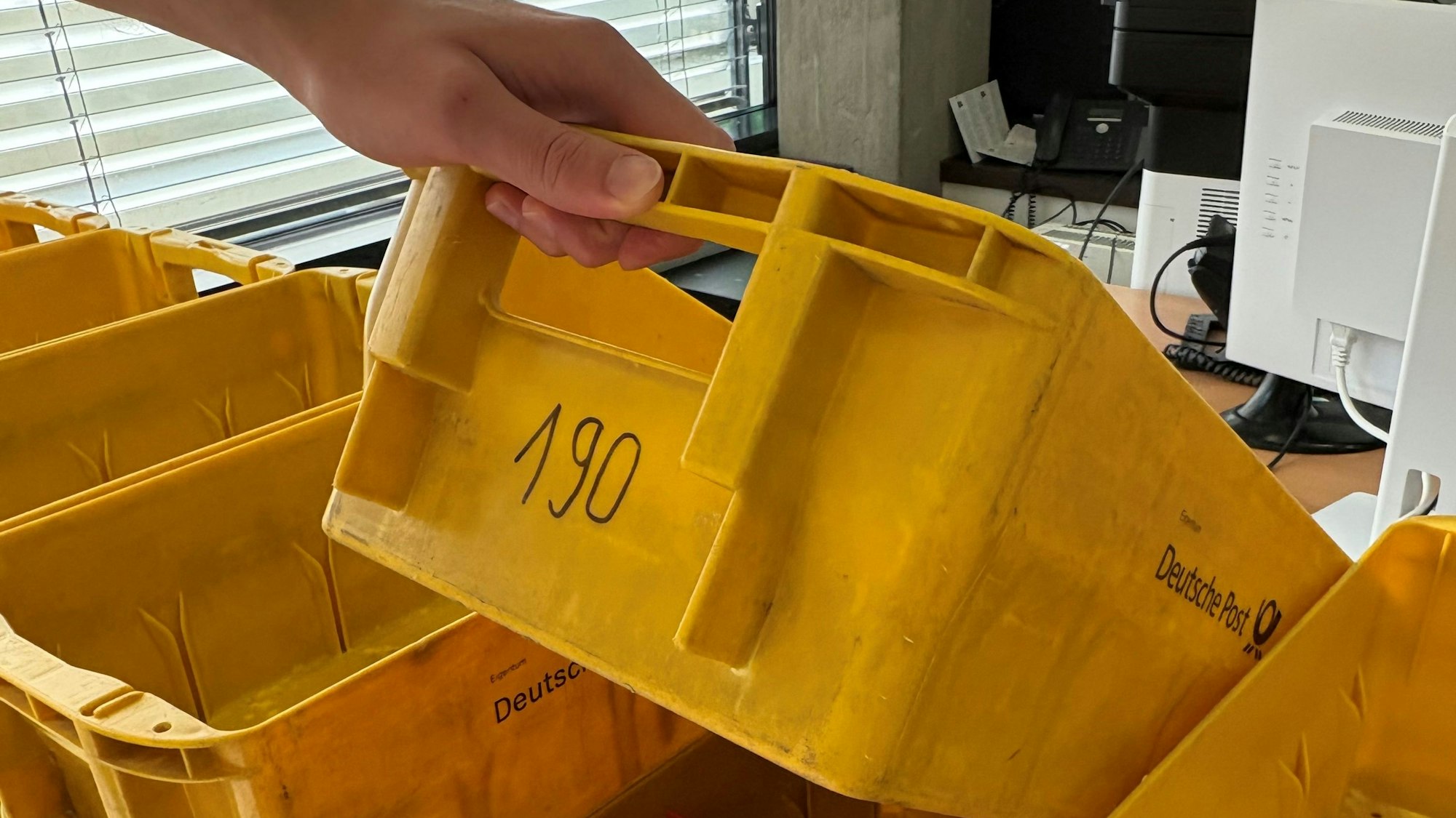 Die Briefwahlunterlagen werden in gelbe Boxen sortiert.