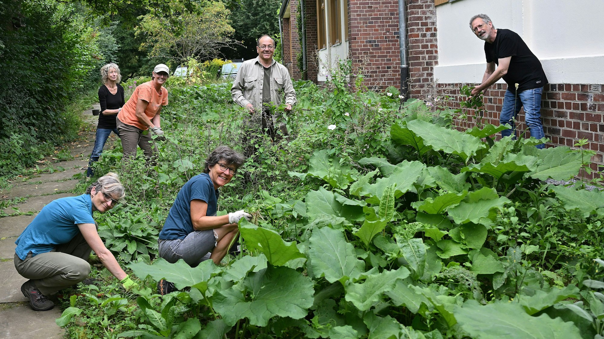 Sechs Helferinnen und Helfer stehen zwischen Pflanzen.