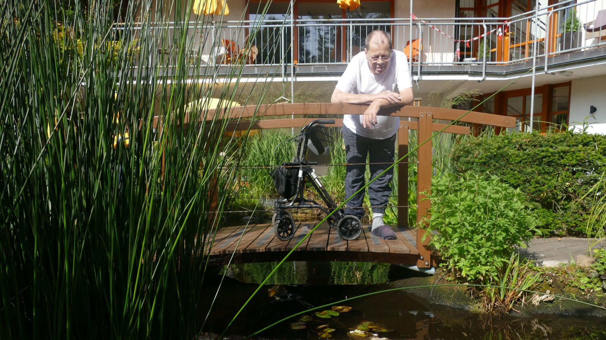 Von der Brücke aus beobachtet Klaus Kleintjes gerne die Zierfische im Gartenteich.