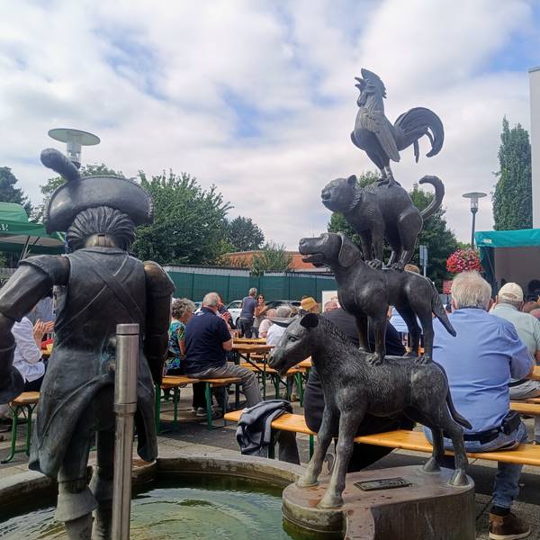 Das Foto zeigt voll besetzte Bänke hinter dem Brunnen beim Brunnenfest.