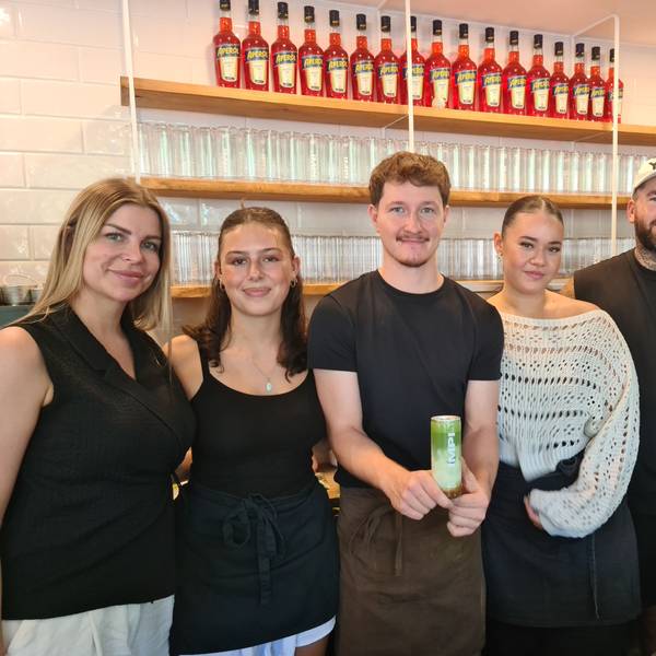 Fünf Menschen stehen nebeneinander hinter der Theke in einem Café.
