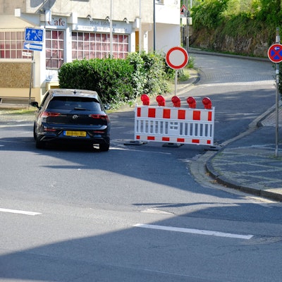 In Heimbach ist die Mariawalder Straße wegen Bauarbeiten abgesperrt. Ein VW Golf mit niederländischen Kennzeichen fährt an der Absperrung vorbei.