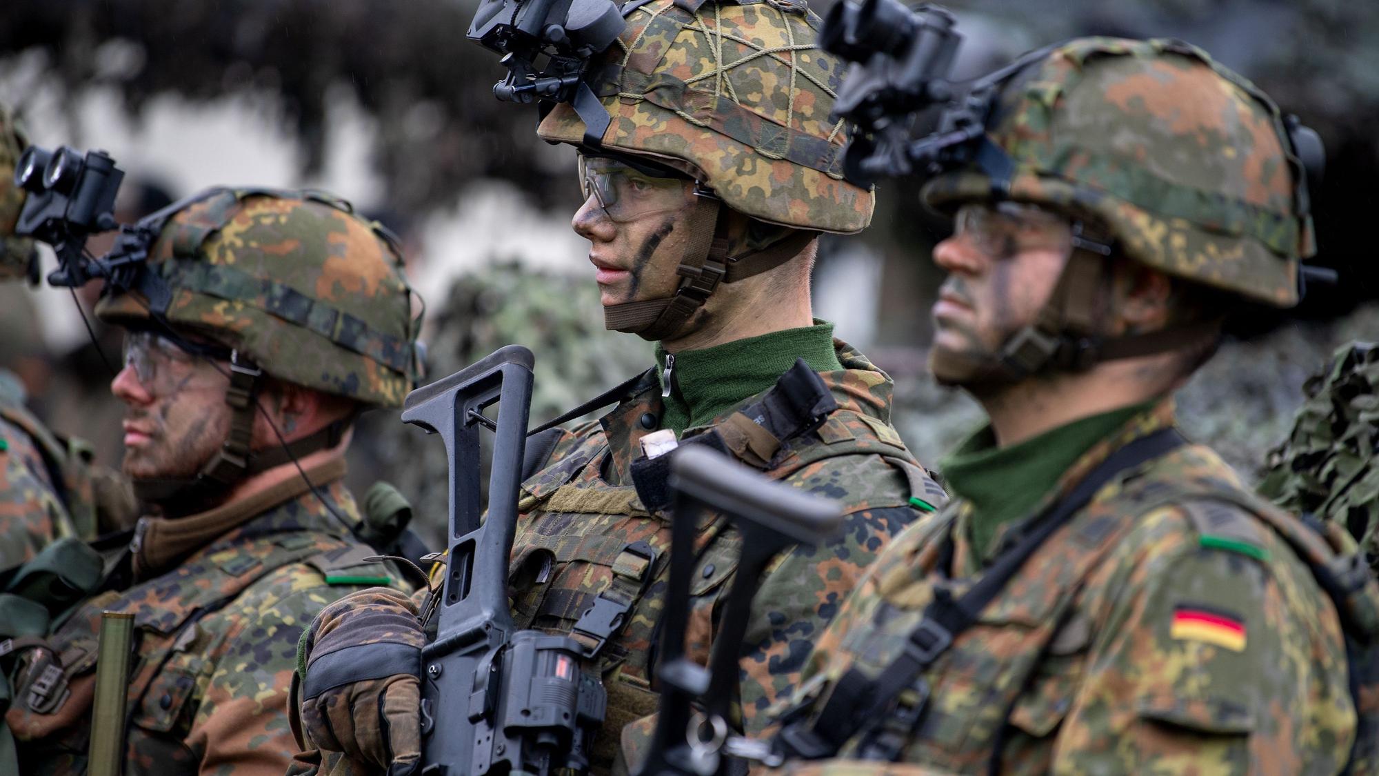 Deutsche Soldaten der Enhanced Forward Presence (eFP) Battle Group in voller Ausrüstung mit Nachtsichtgeräten auf den Helmen warten auf den Besuch der deutschen Verteidigungsministerin.