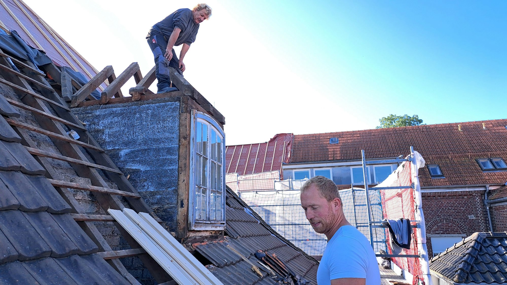 Das Foto zeigt zwei Arbeiter auf dem Dach des Wipperfürther Rathauses