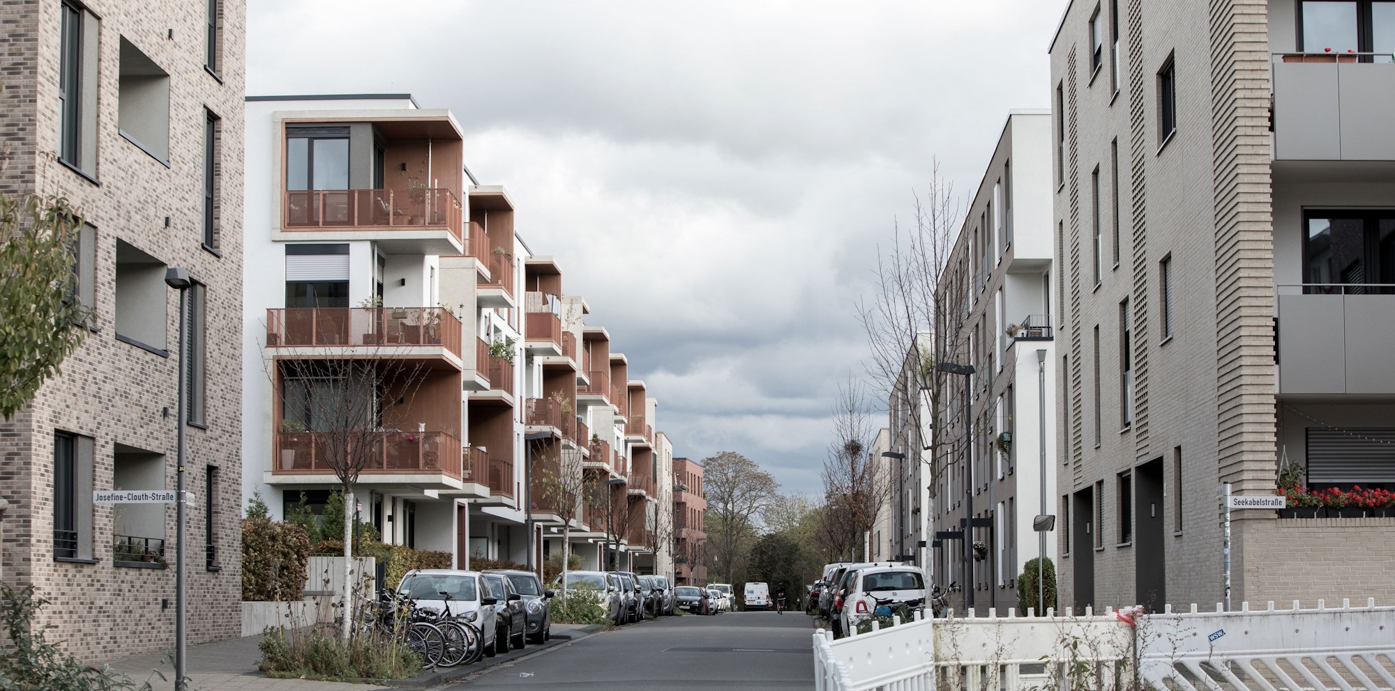 An einer Straße stehen neugebaute Wohnblöcke.