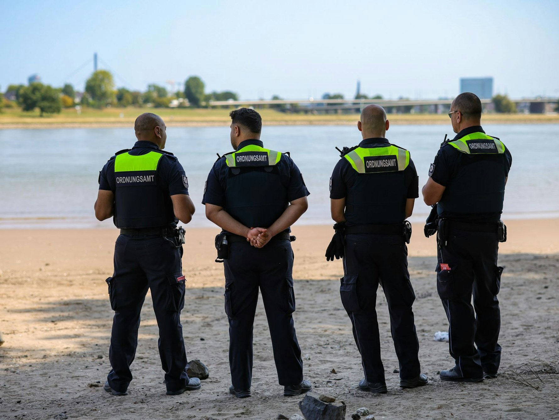 Mitarbeiter des Düsseldorfer Ordnungsamtes kontrollieren das Badeverbot im Rhein. (Archivbild)