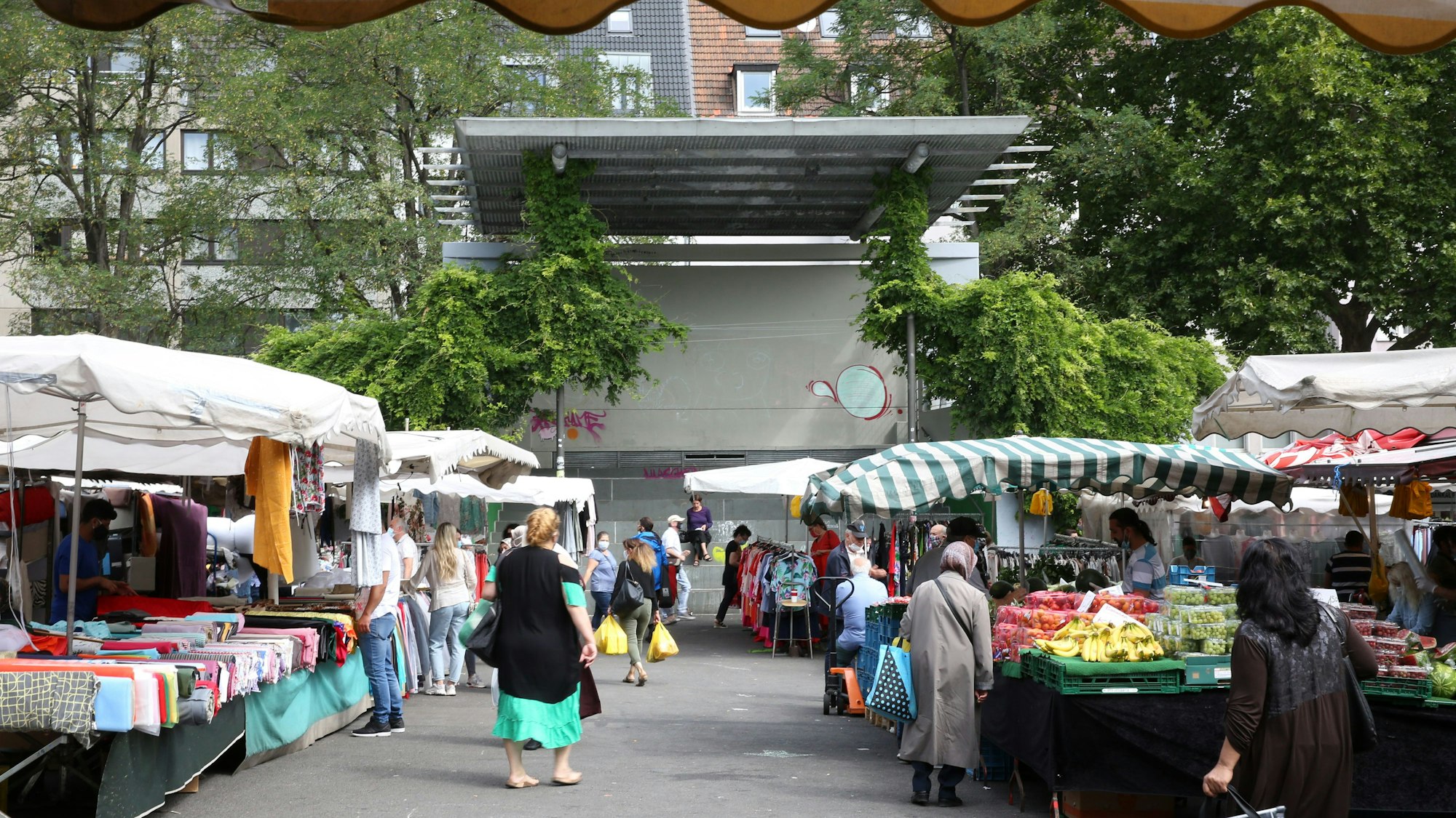 Auf einem Platz mit Freilicht-Tribüne sind Marktstände aufgebaut.