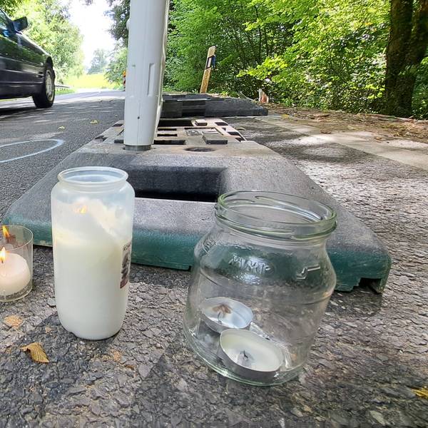 Zwischen Warnbaken stehen Kerzen auf der Dürschtalstraße, auf der sich am Samstag (16.8.) ein tödlicher Unfall ereignet hat, bei dem vier Teenager im Alter von 14 bis 19 Jahren ums Leben kamen.