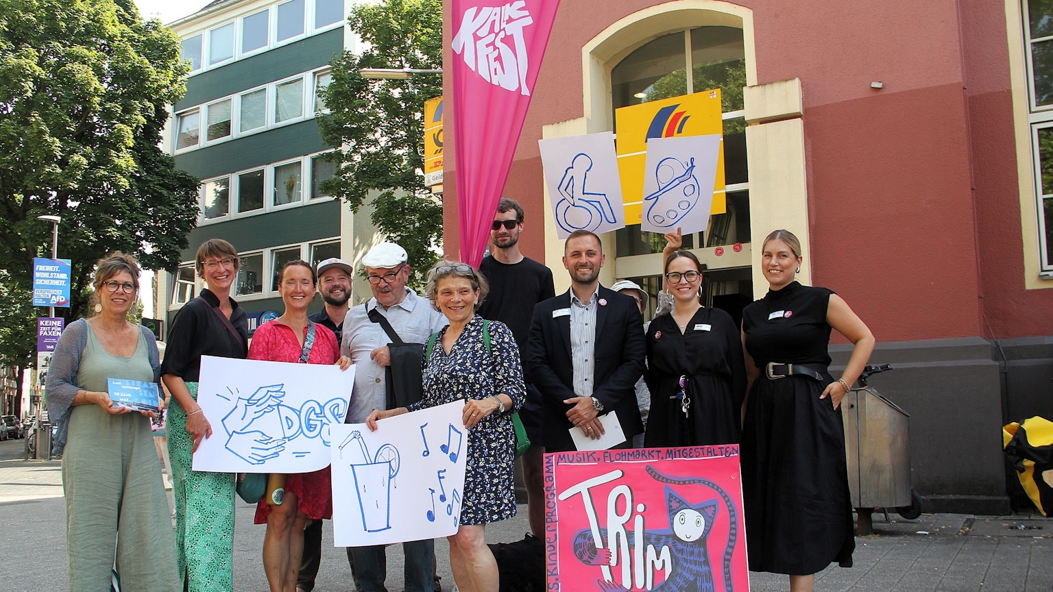 Die Veranstalter und Sponsoren von drei Kalker Straßenfesten stehen nebeneinander und halten Plakate zu ihren Aktionen in den Händen.