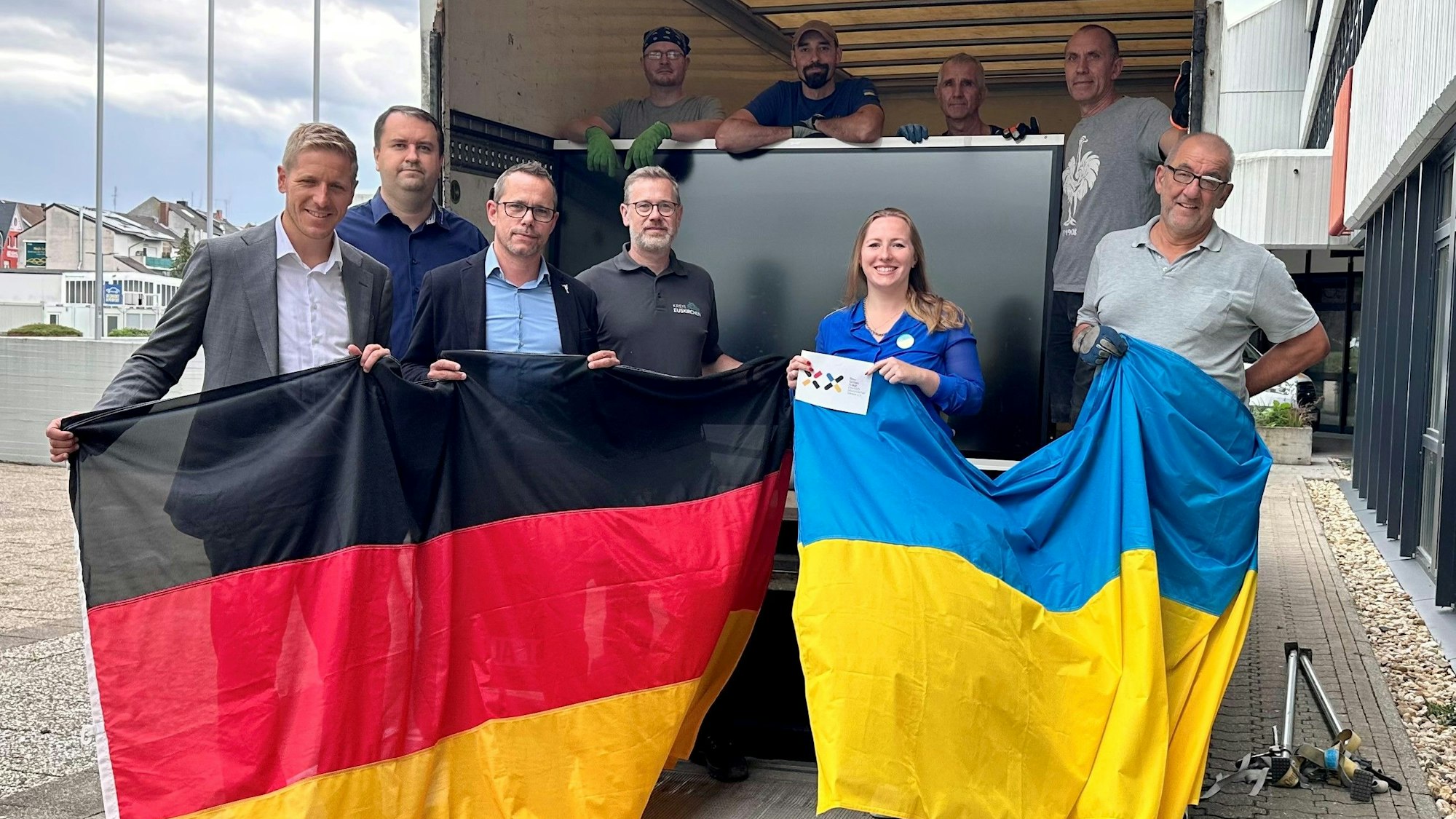 Eine Gruppe Menschen hält eine Deutschland- und eine Ukraineflagge. Zu ihnen gehören Landrat Markus Ramers und die Vertreterin des Vereins Blau-Gelbes Kreuz, Nadiia Khmeliuk.