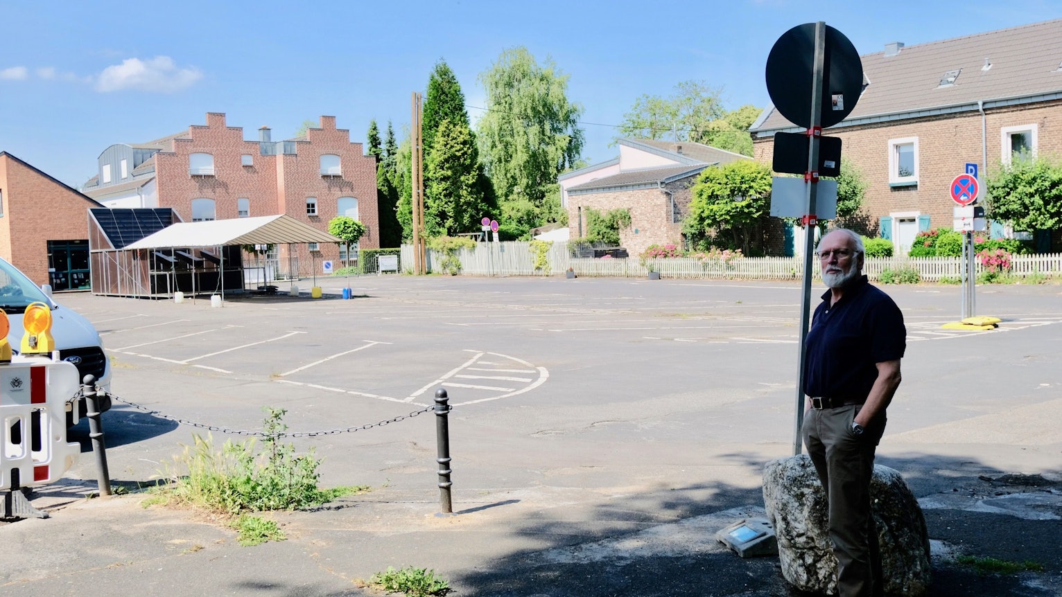 Ein Mann mit weißem Bart steht am Rand des Kirchplatzes in Lövenich.