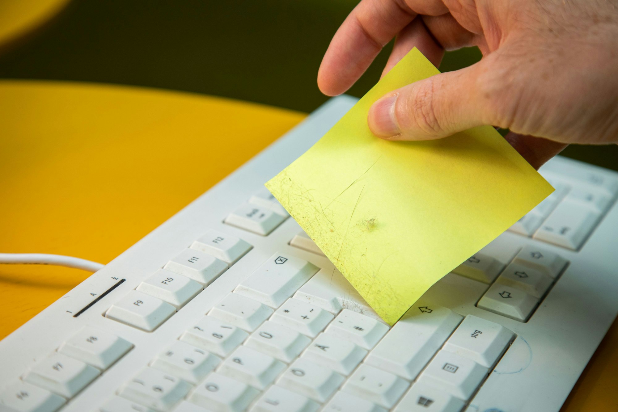- Fazit: Der Hack funktioniert - der Schmutz aus den Tastatur-Zwischenräumen bleibt am Klebezettel haften.