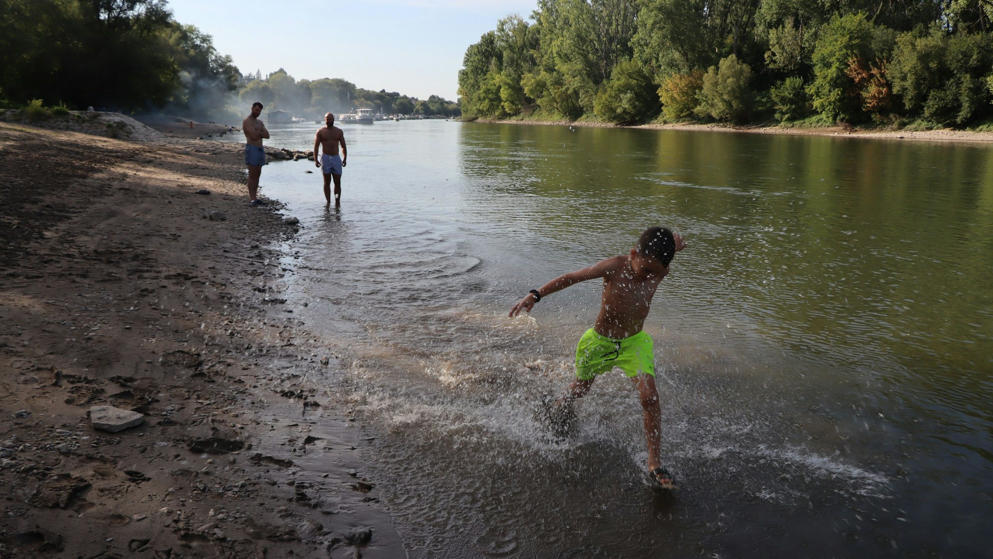 Ein Junge planscht am Ufer des Herseler Werths in Bornheim.