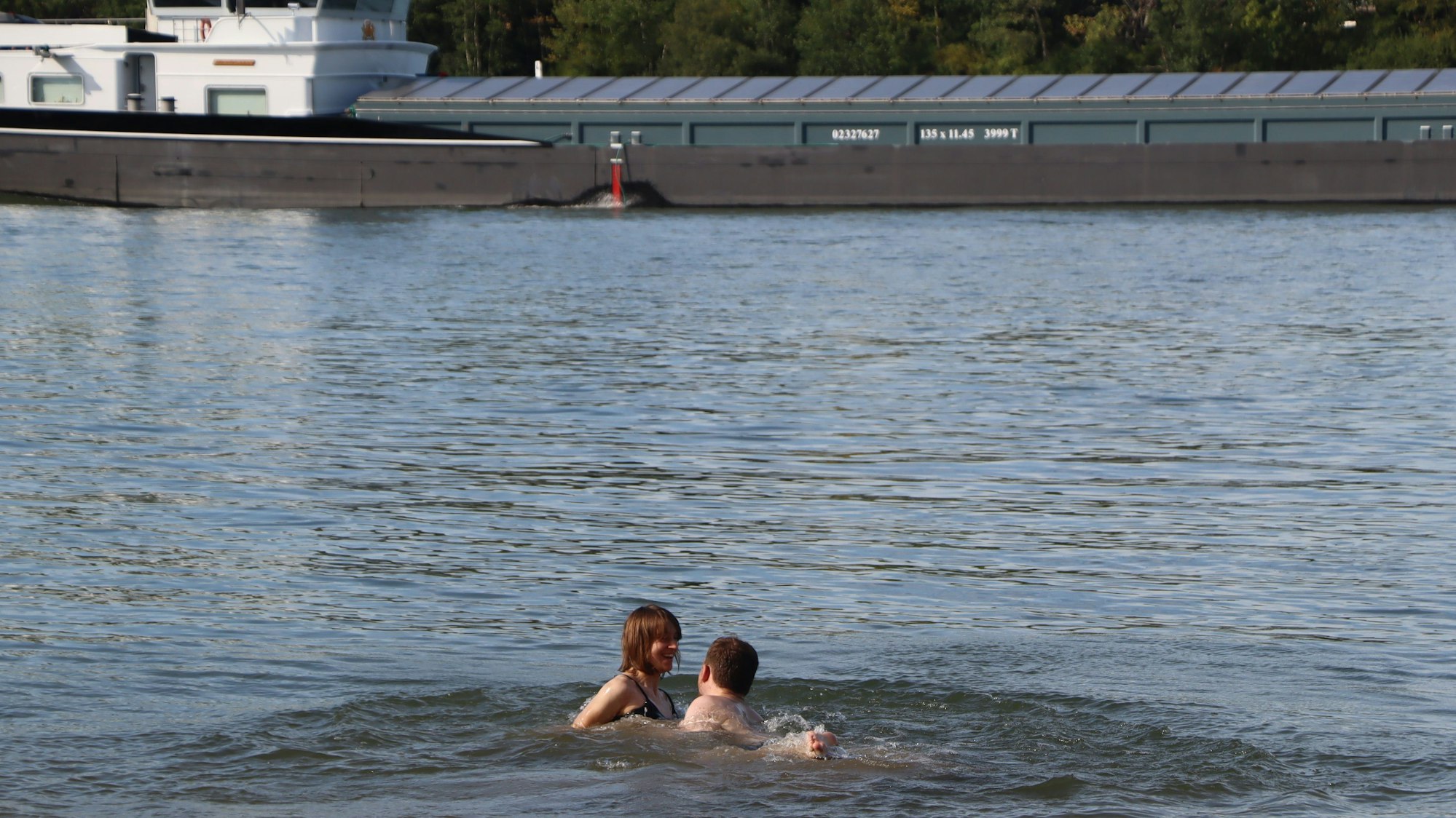 Das Bild zeigt zwei Personen im Rhein bei Wesseling.