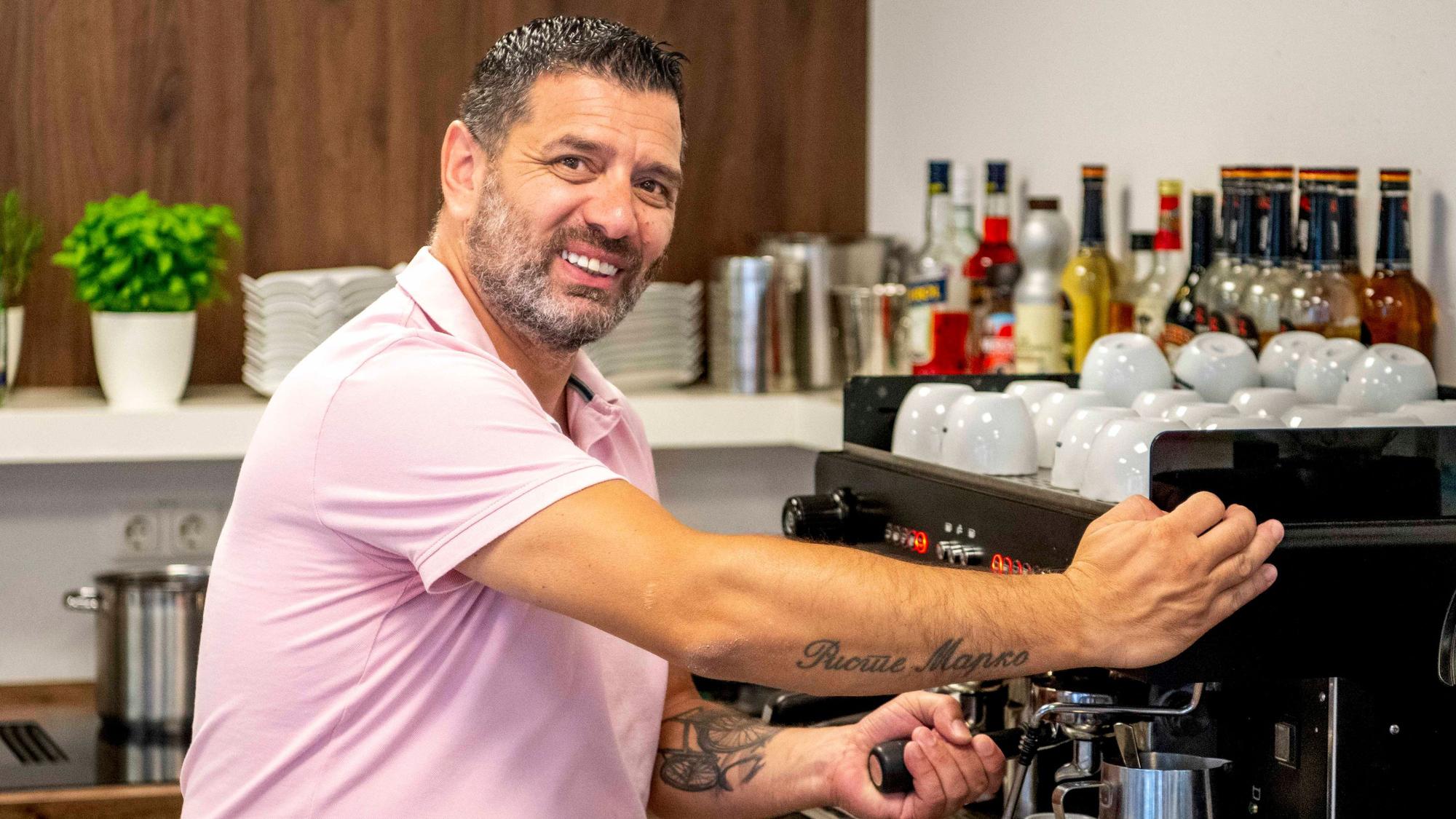 Das Bild zeigt den neuen Chef des Cafés, der gerade einen Kaffee zubereitet.