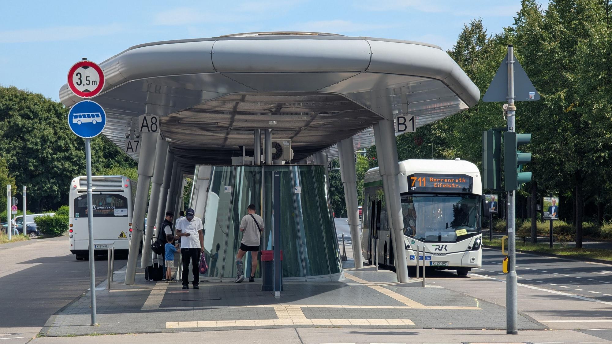 Das Foto zeigt zwei Busse und wartende Fahrgäste am Busbahnhof in Hürth-Mitte.