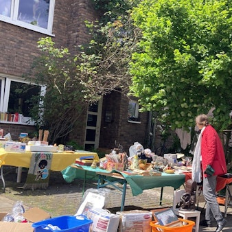 Eine Kundin schaut sich einen Flohmarktstand an.