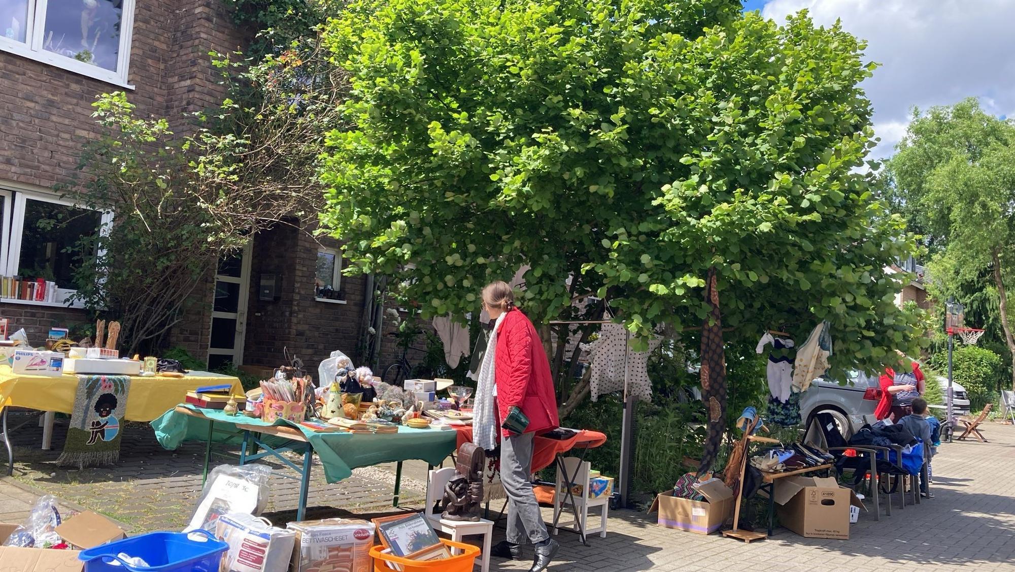 Eine Kundin schaut sich einen Flohmarktstand an.