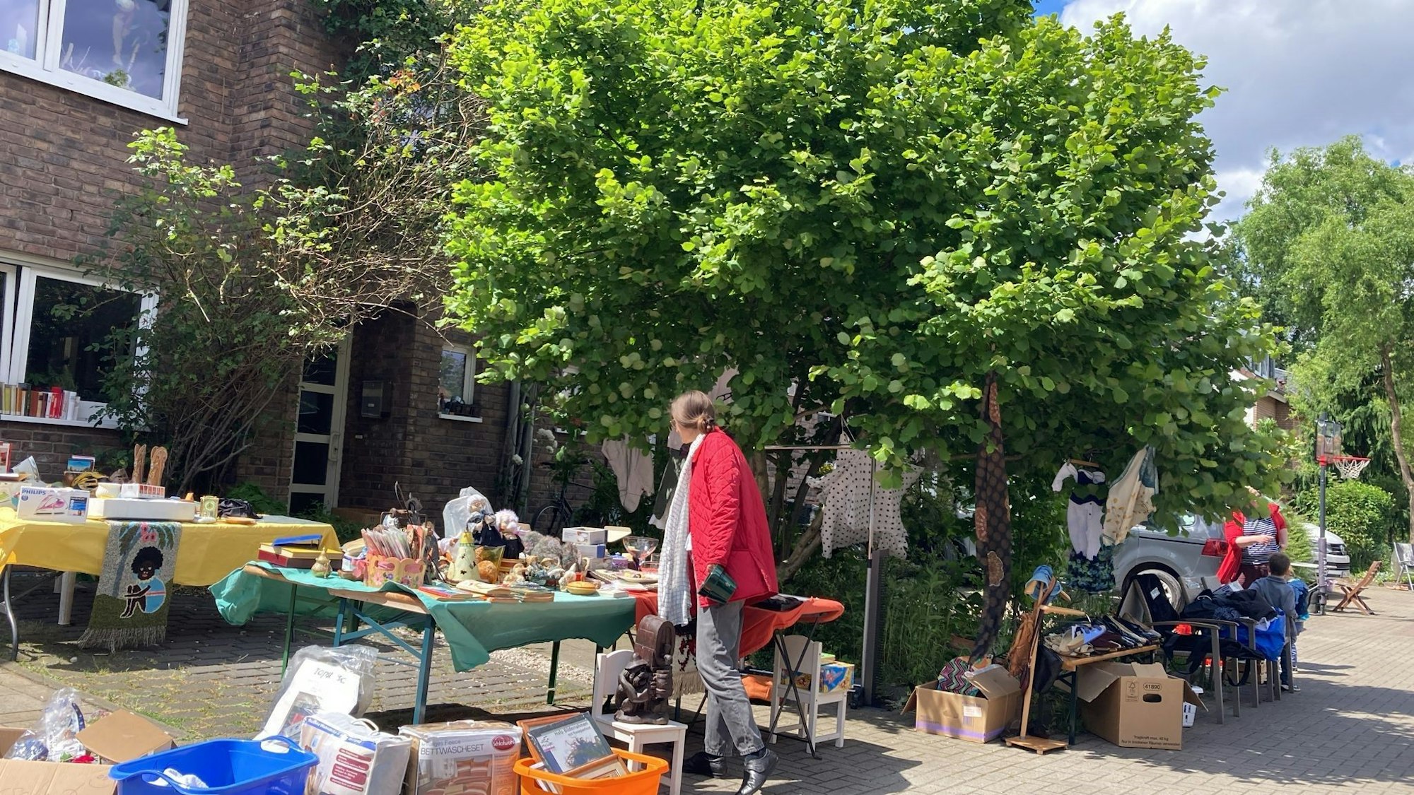Eine Kundin schaut sich einen Flohmarktstand an.