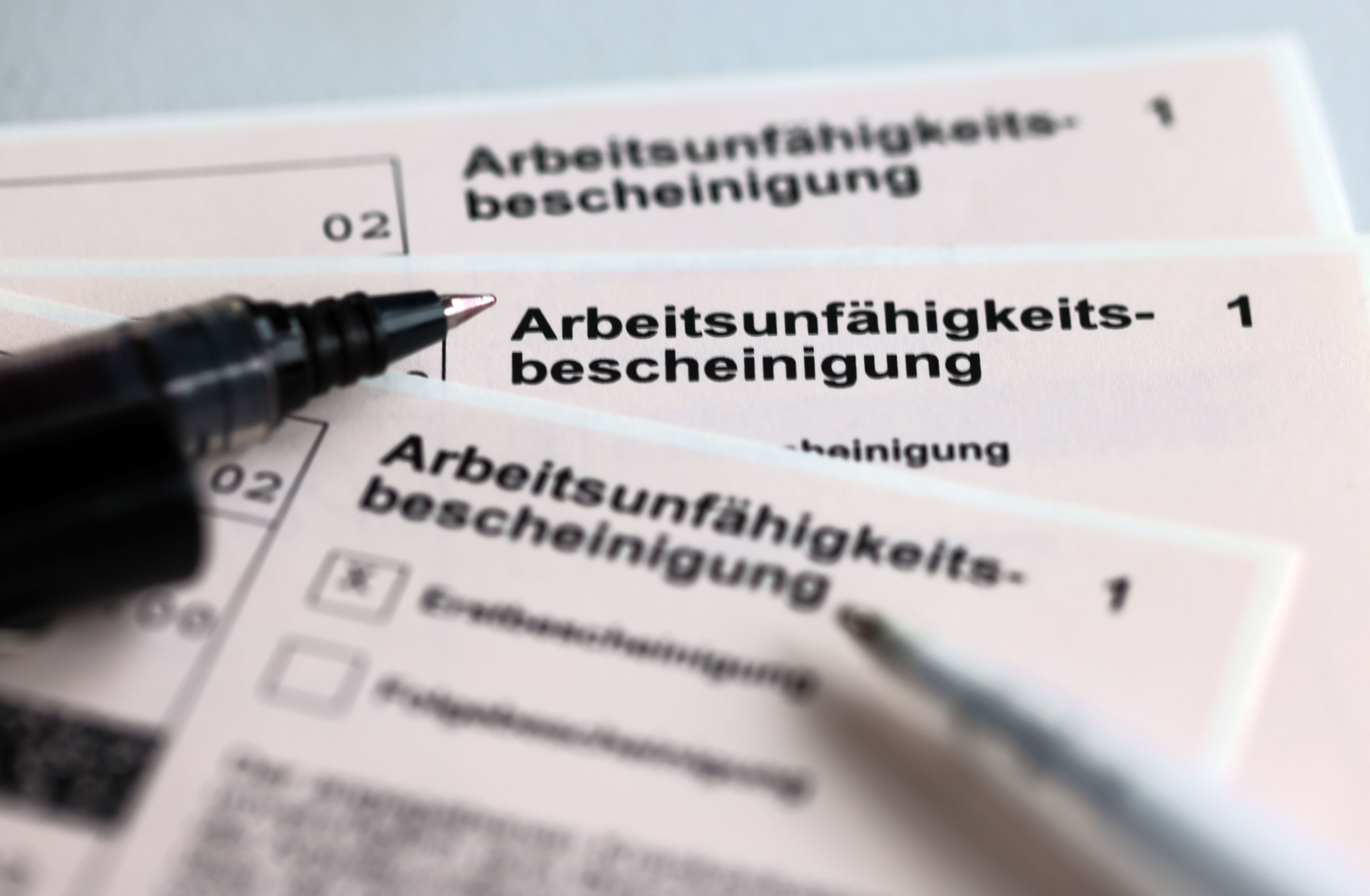 Arbeitsunfähigkeitsbescheinigung mit Kugelschreiber daneben.
