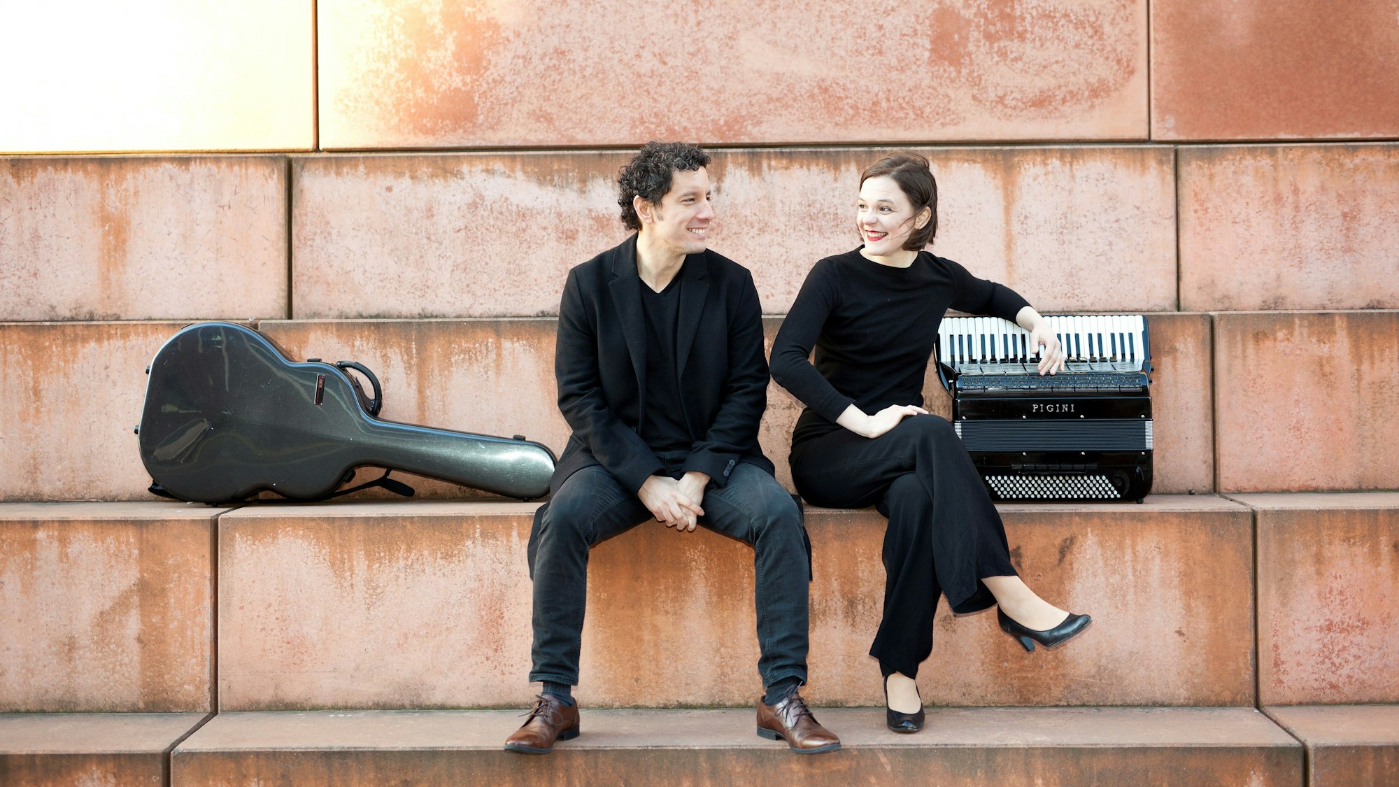 Auf dem Bild sind eine Frau und ein Mann mit ihren Instrumenten zu sehen.