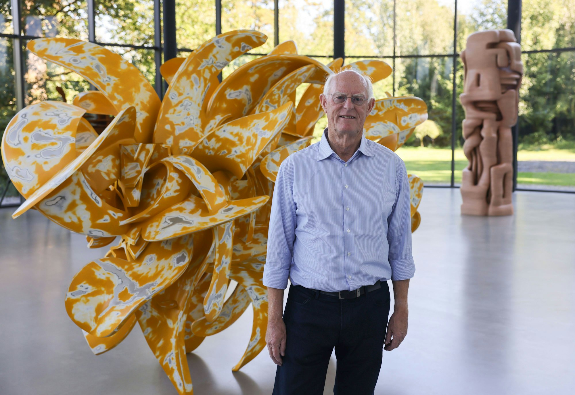 Der Künstler Tony Cragg steht vor der Skulptur „Industrial Nature“.